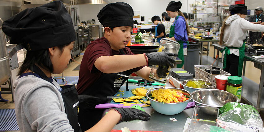Students preparing their dishes for the 2025 cooking competition.
