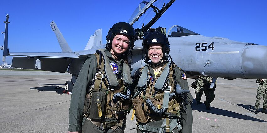 Castlemont teacher, Hailey Robinson, and the Navy pilot she flew with in the F-18 (pictured behind them).