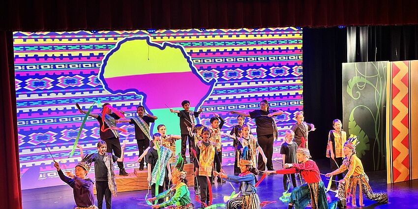 stage full of young students performing Lion King Jr.