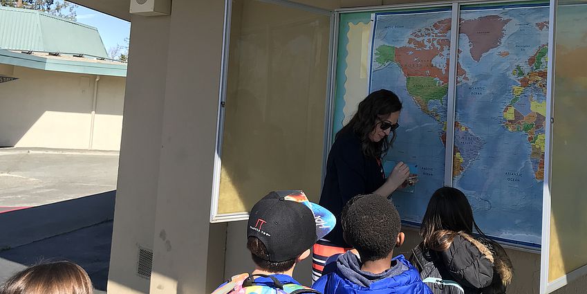 Mrs. Wellendorf putting pins in our world map