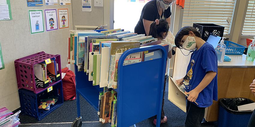 A student looking at a library cart