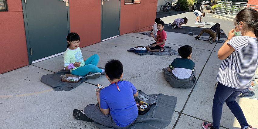 Students sitting on blankets during recess