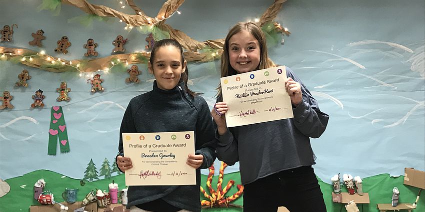 Two students showing their awards