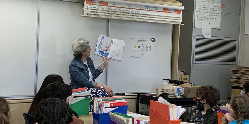 A volunteer reading to a class