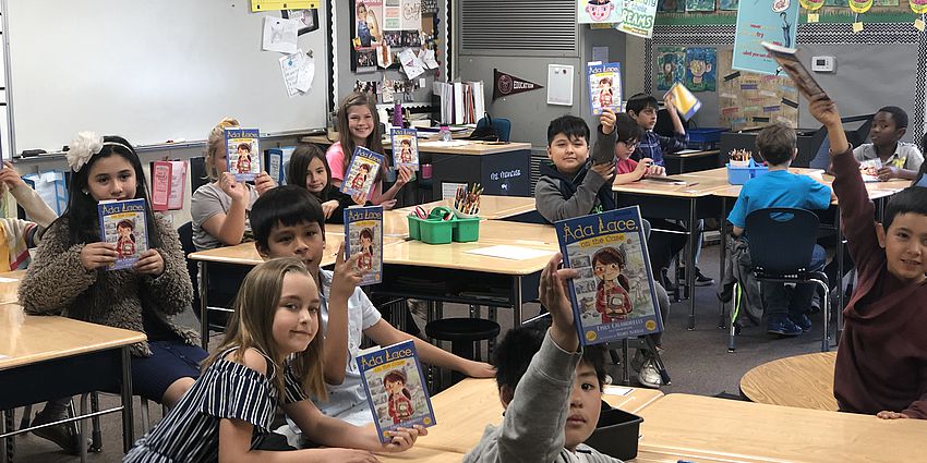 students holding up a book