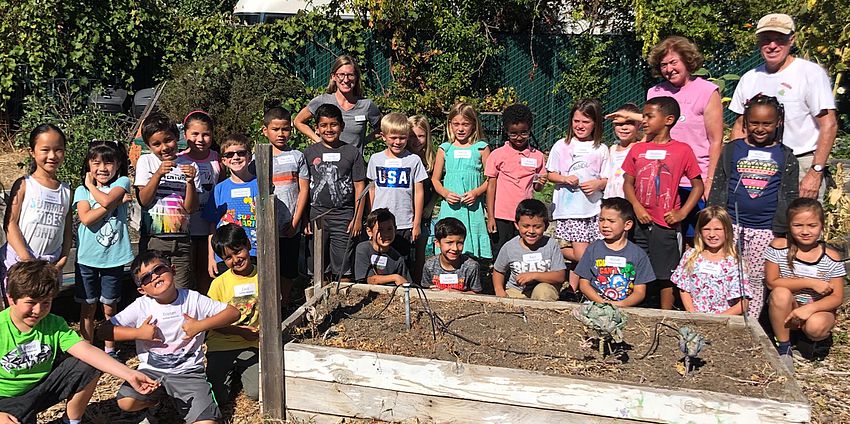 Students and teachers around a planting box