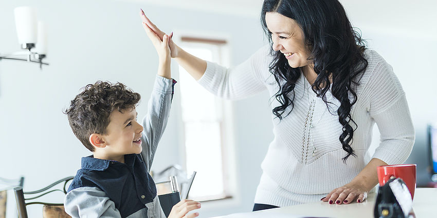 Student and parent high fiving.