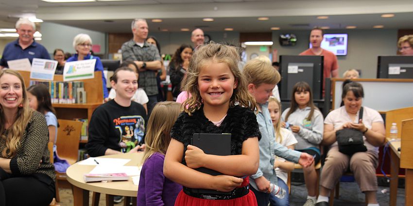 young girl happy holding a book