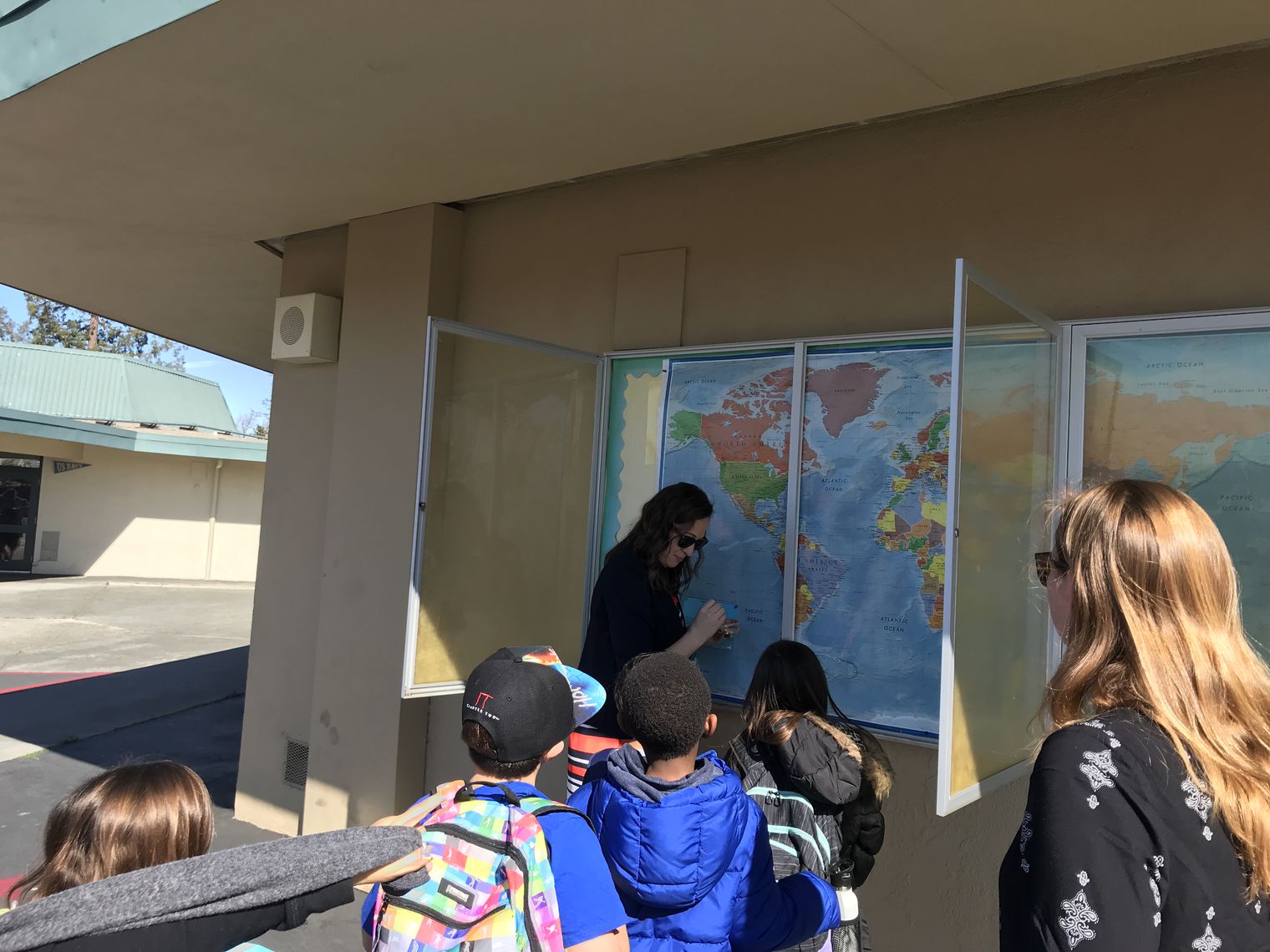 Mrs. Wellendorf putting pins in our world map