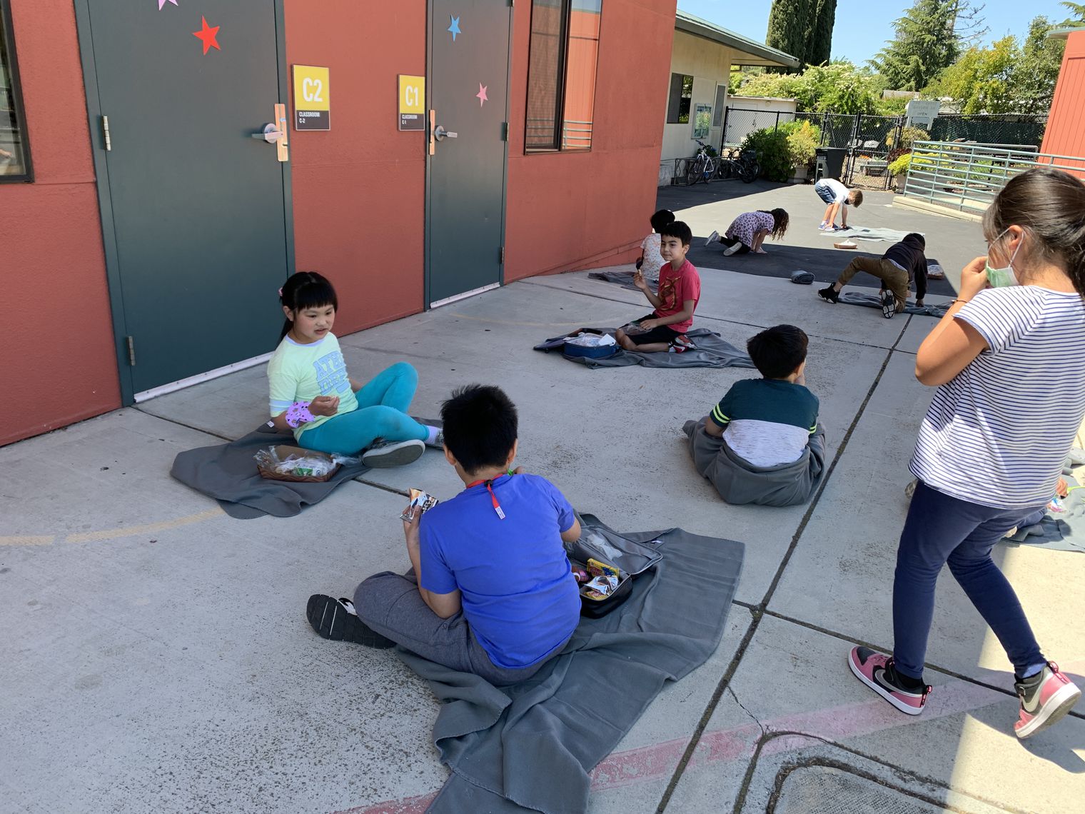Students sitting on blankets during recess
