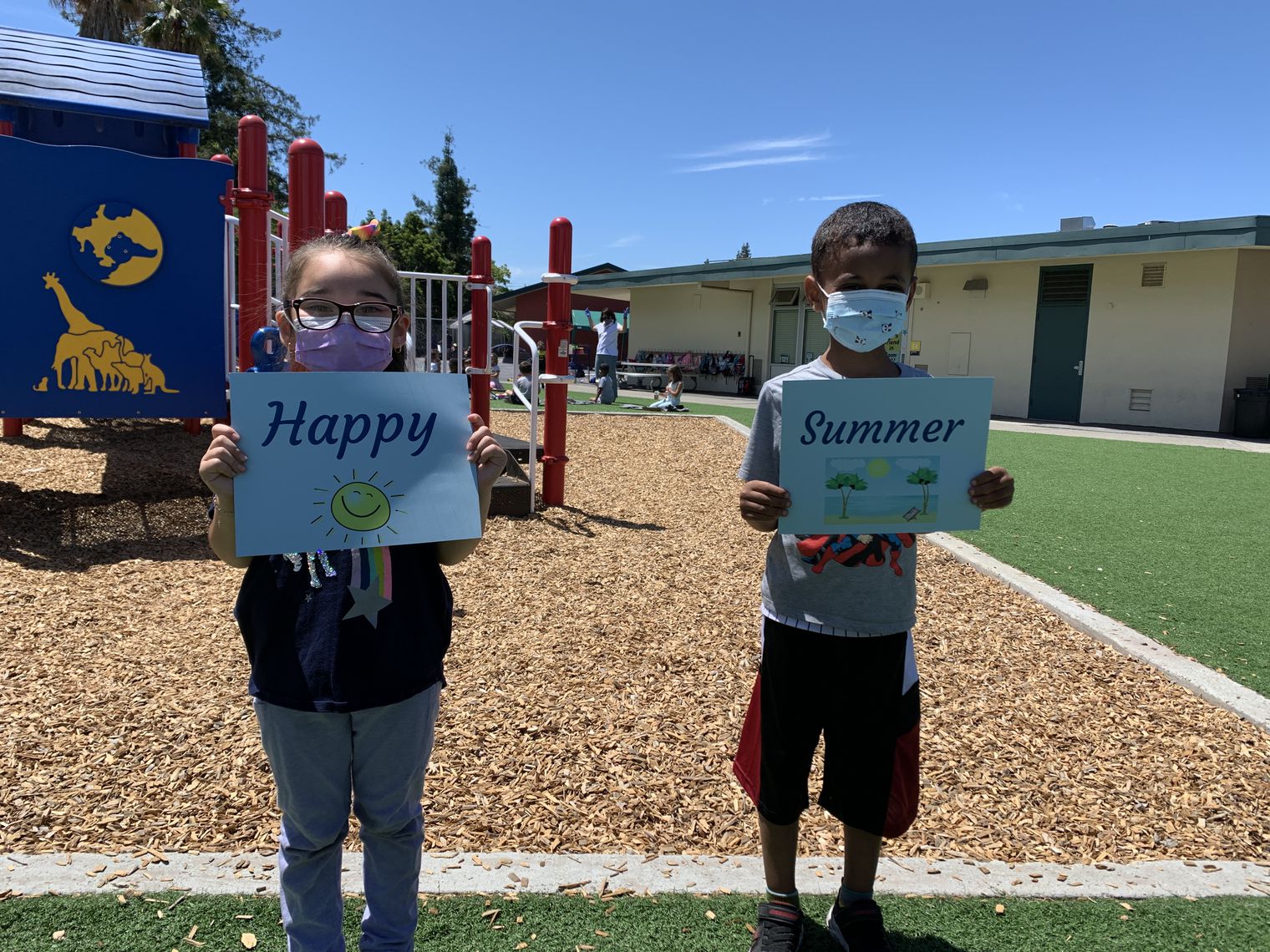 Two students holding "Happy Summer" Signs