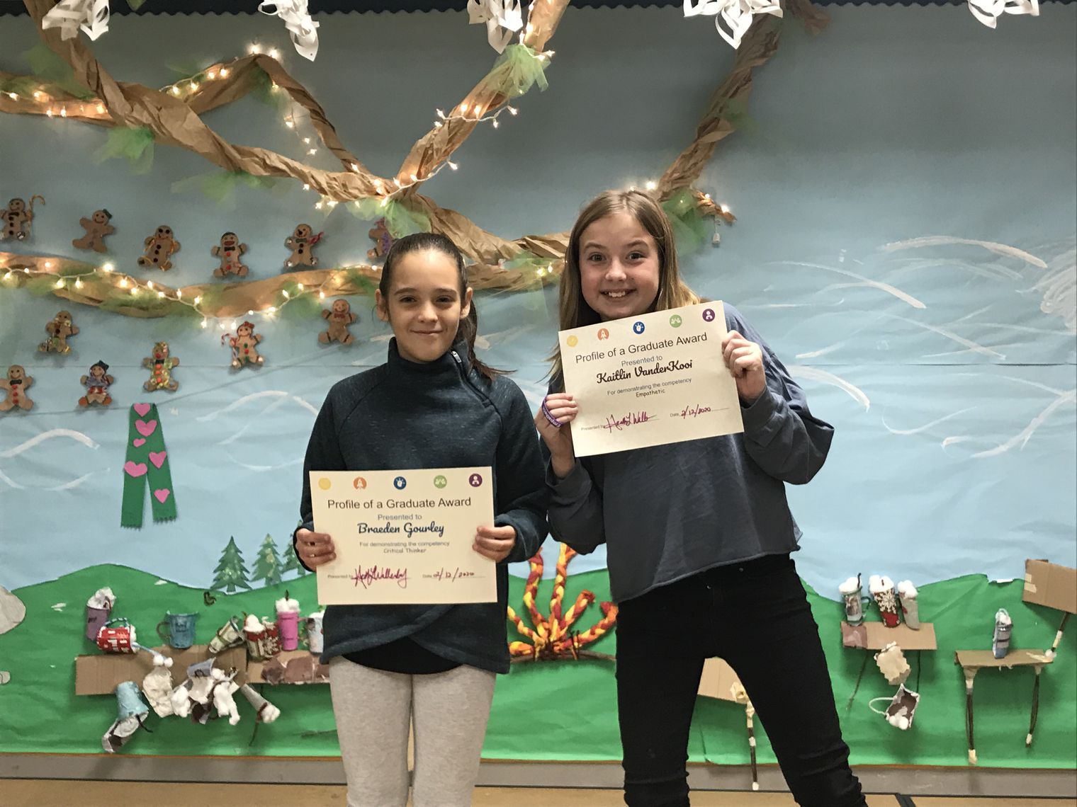Two students showing their awards