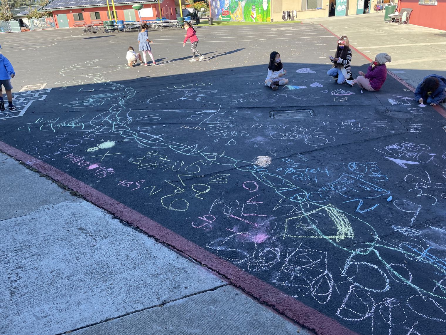 Kindergarten outside using chalk