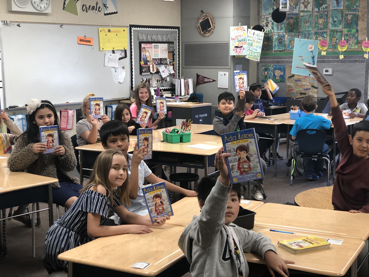 students holding up a book