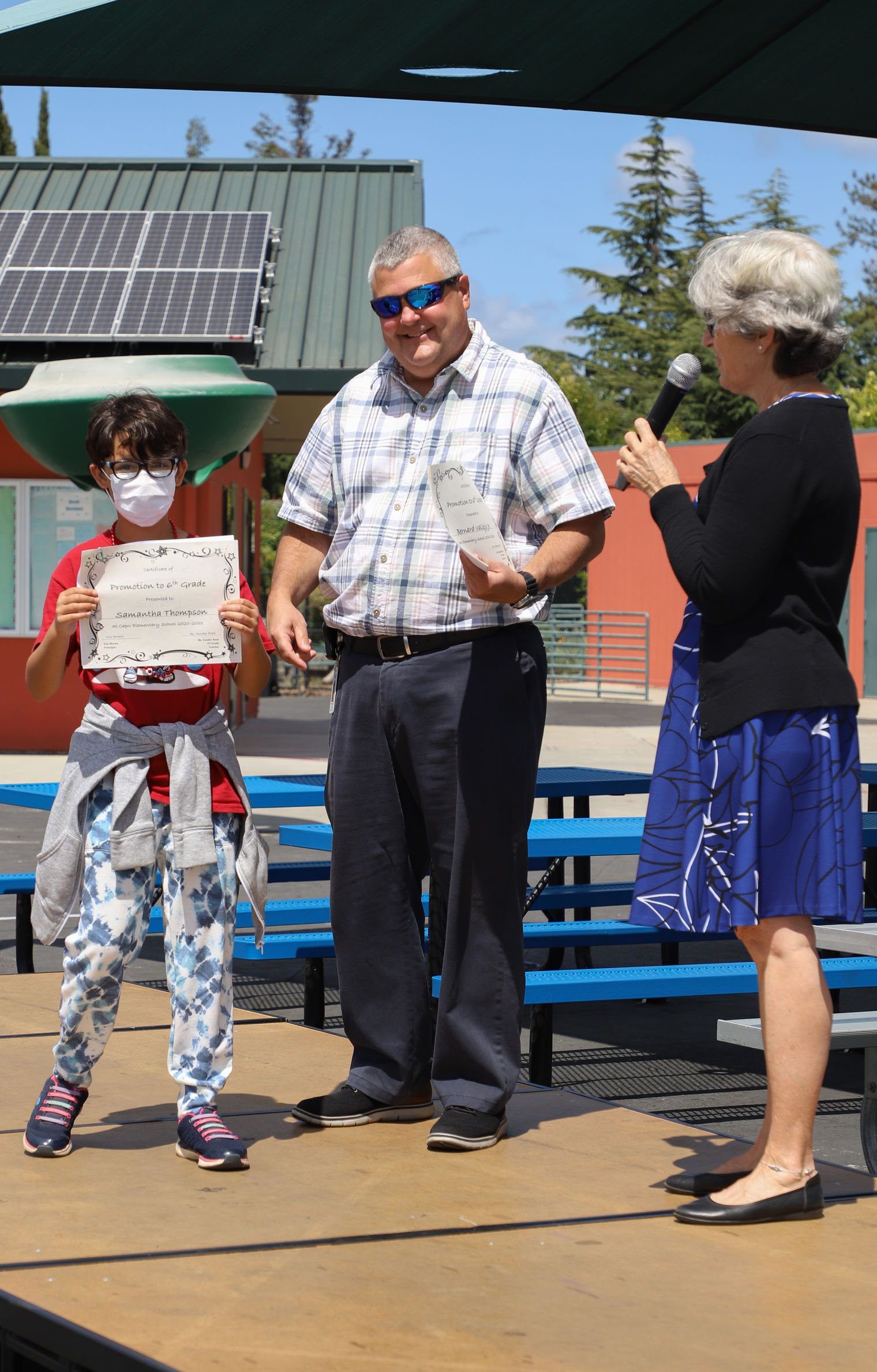 Mr. Brown presenting a promotion certificate to a student