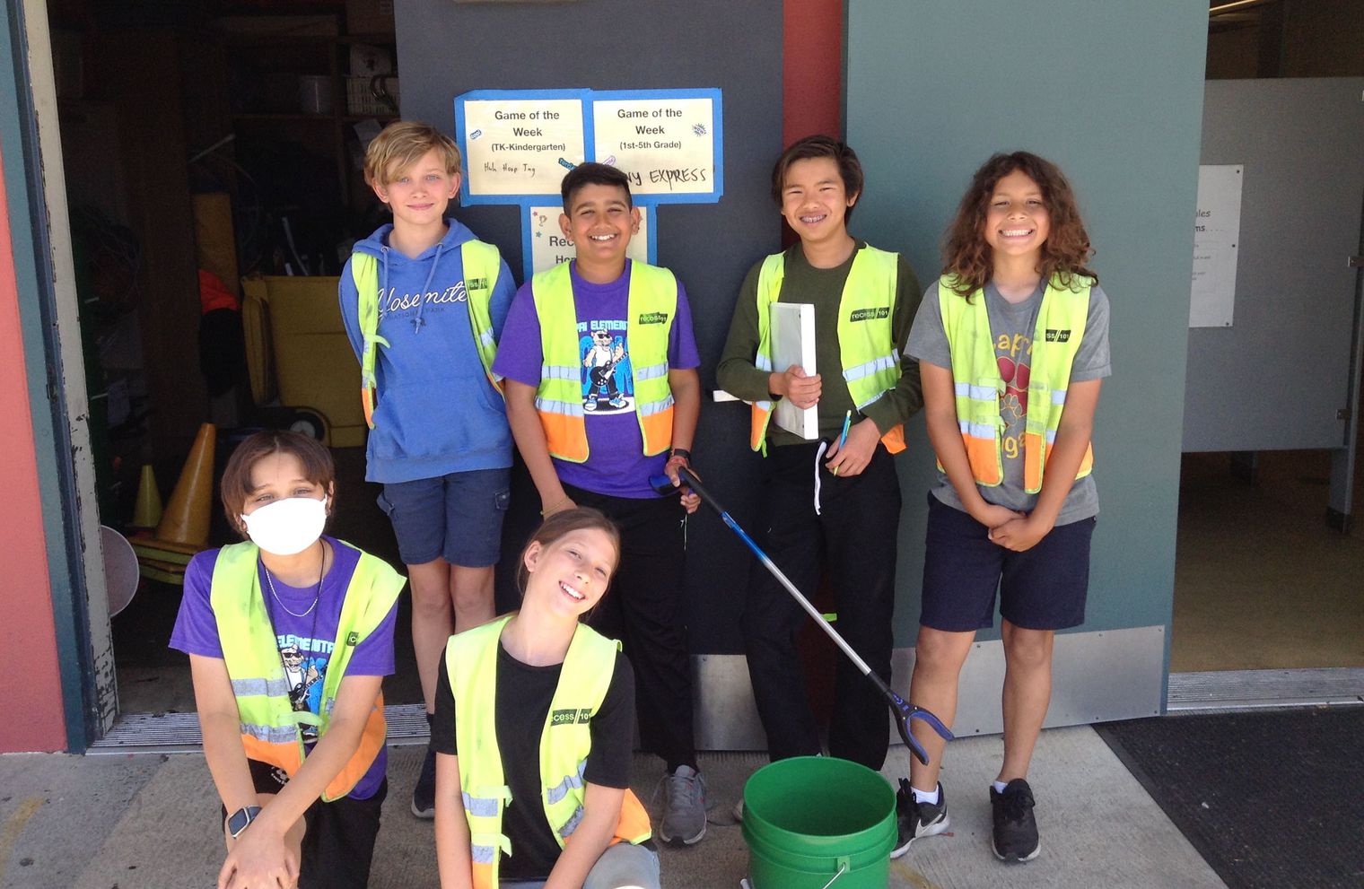 six elementary students in yellow vests smiling