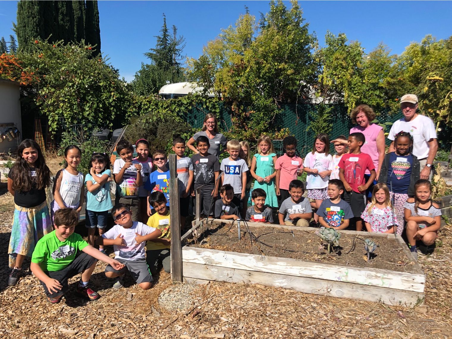 Students and teachers around a planting box