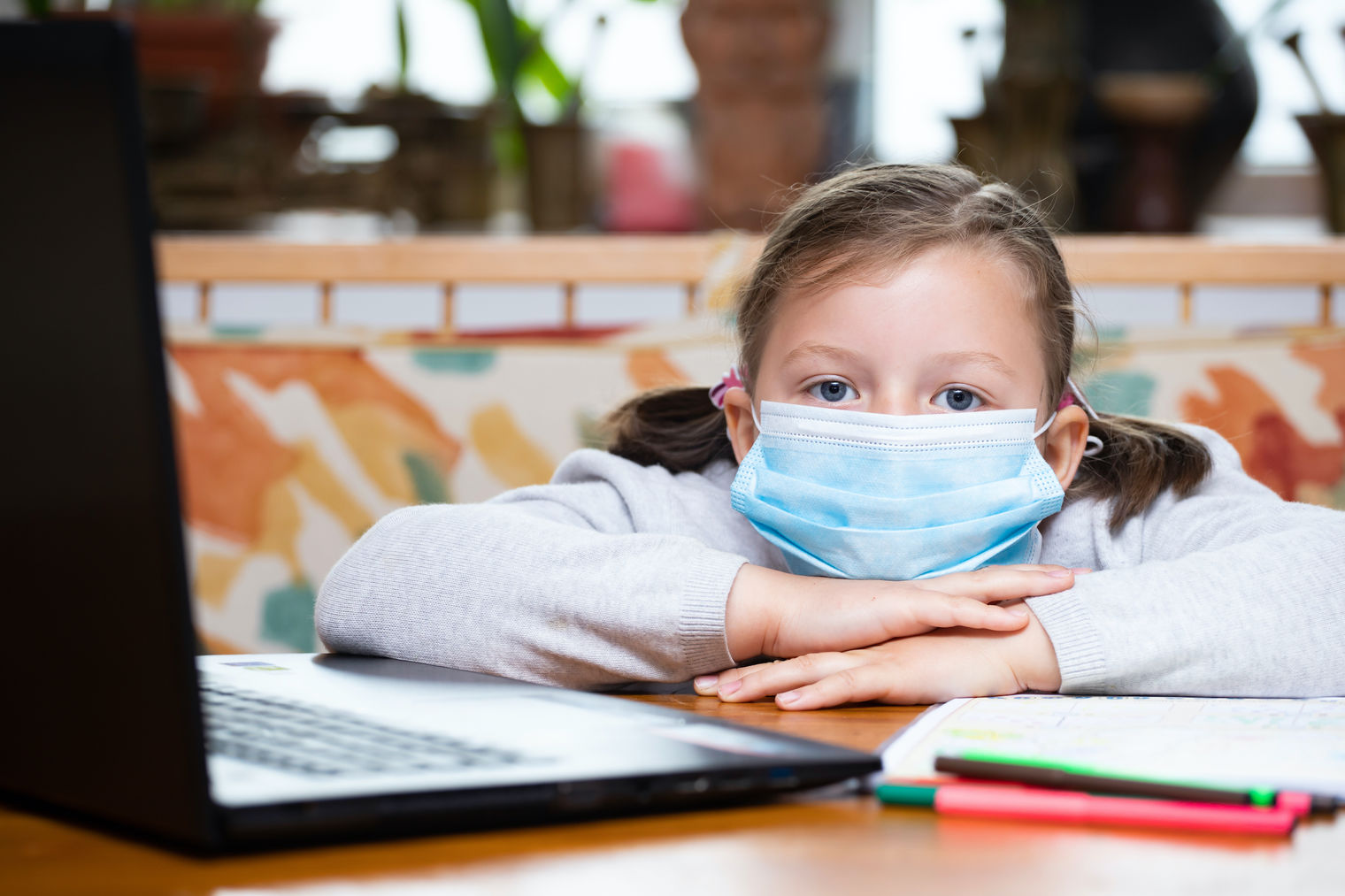 Young girl with mask at a computer