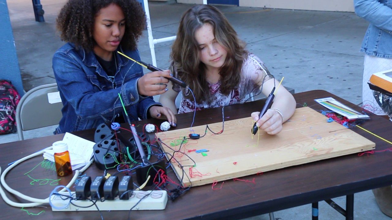 two girls demonstrating use of 3-D pens