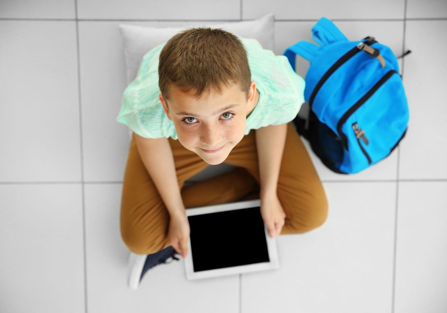boyon floor with digital tablet smiling
