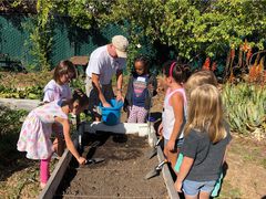 Students and teachers around a planting box