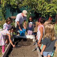 Students and teachers around a planting box