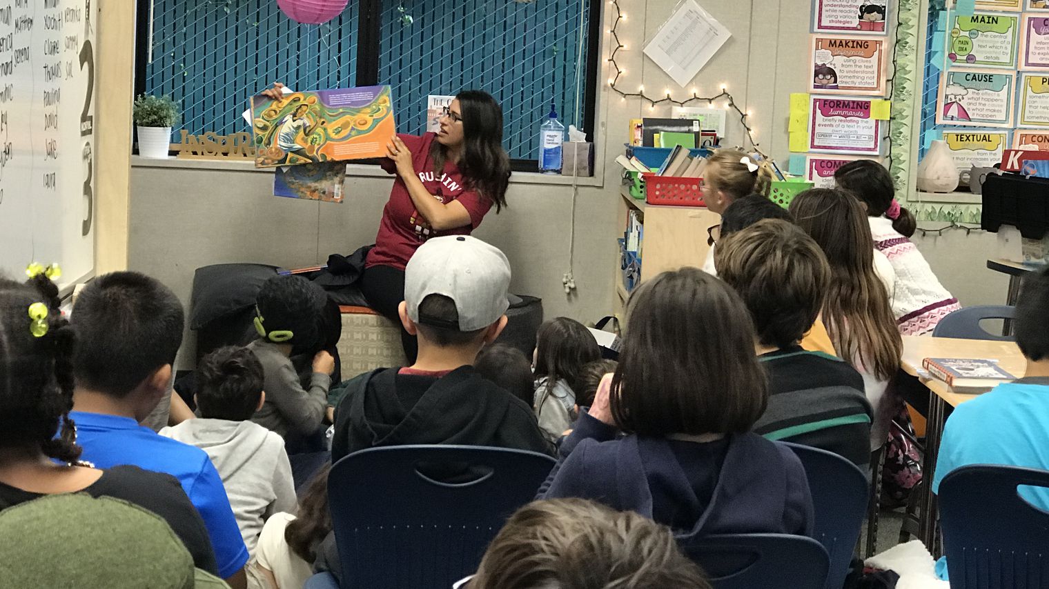 Parent volunteer reading to students