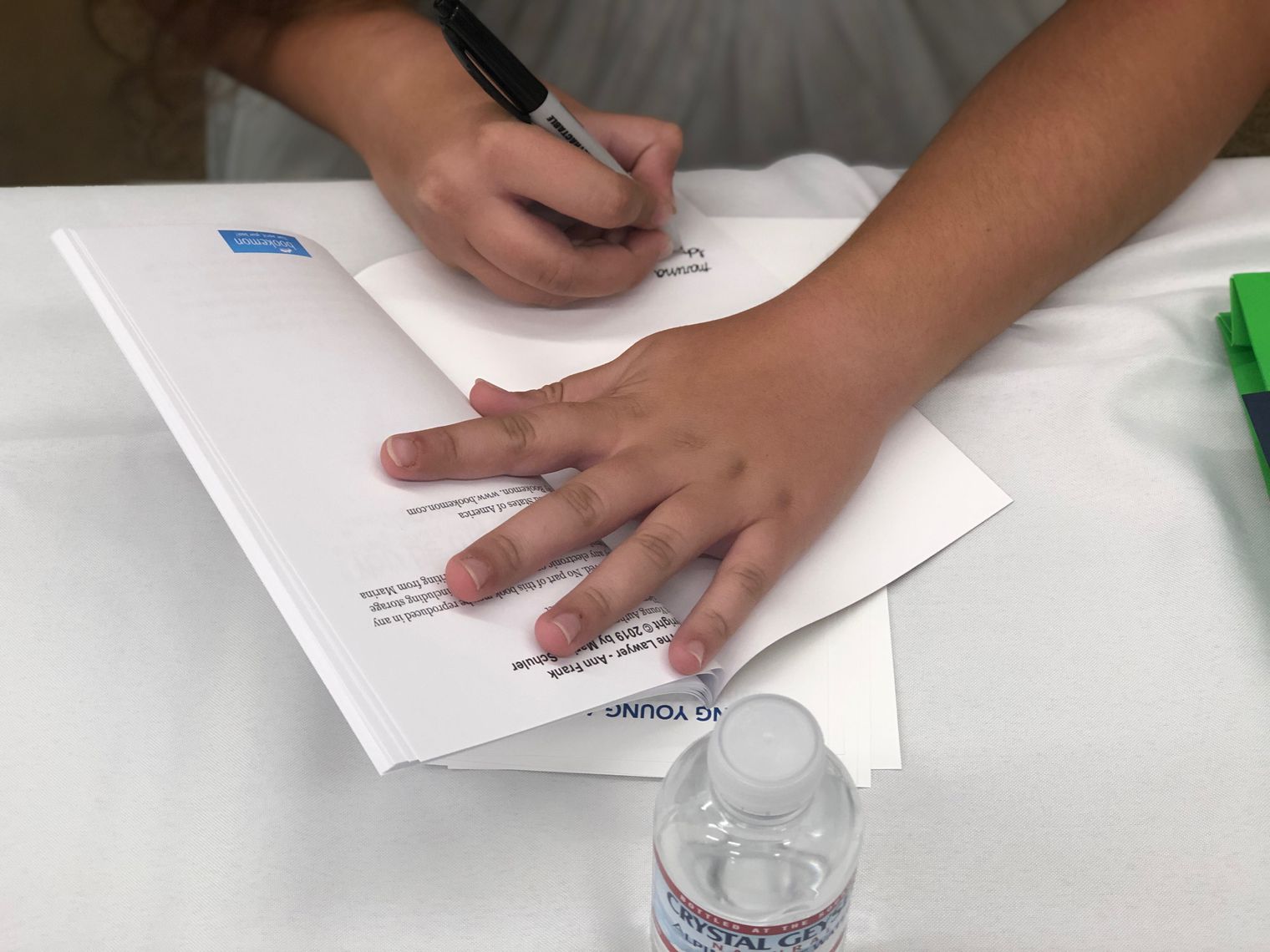 hands signing a book.